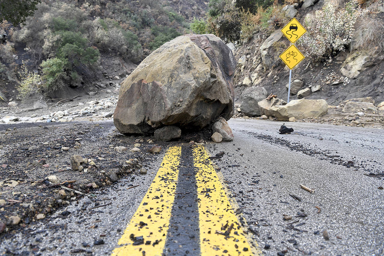 A large boulder sits in the middle of Bella Vista Drive in Montecito, California, following the rain storm, on Tuesday. (AP Photo/Michael Owen Baker)