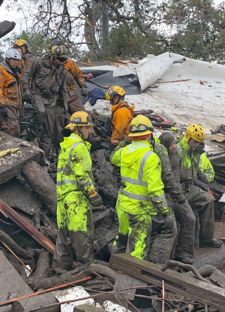 Firefighters successfully rescue a 14-year-old girl (right) after she was trapped for hours inside a destroyed home in Montecito, California on Tuesday. (Mike Eliason/Santa Barbara County Fire Department via AP)
