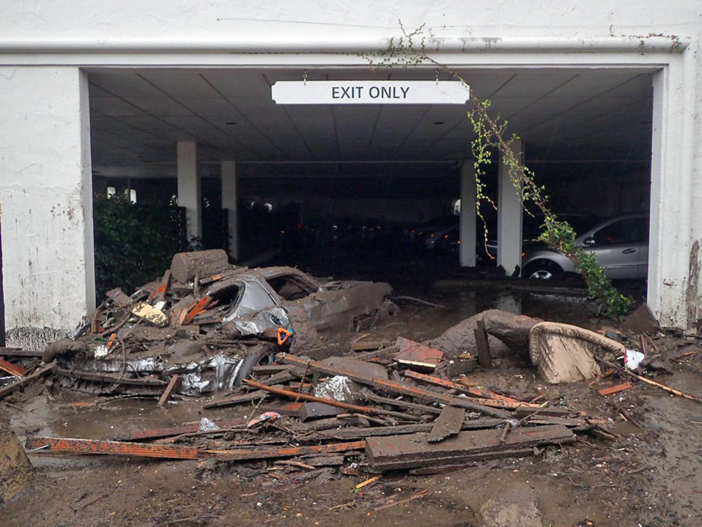 Damaged vehicles were carried by mud flow and debris at the parking garage of The Montecito Inn in Montecito, California, on Tuesday. (Mike Eliason/Santa Barbara County Fire Department via AP)
