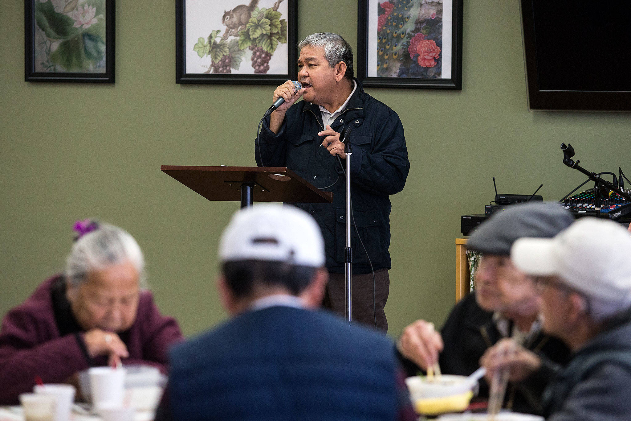 Hau Tran sings as Vietnamese seniors eat at Homage’s Center for Healthy Living on Jan. 10 in Lynnwood. Each weekday the center offers its room for various cultures to get together for activities and lunch while speaking their native languages. (Andy Bronson / The Herald)