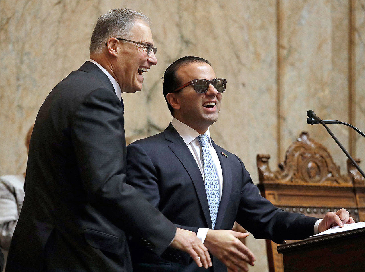 Gov. Jay Inslee (left) is introduced by Lt. Gov. Cyrus Habib for Inslee’s annual state-of-the-state address before a joint legislative session Tuesday in Olympia. (AP Photo/Elaine Thompson)