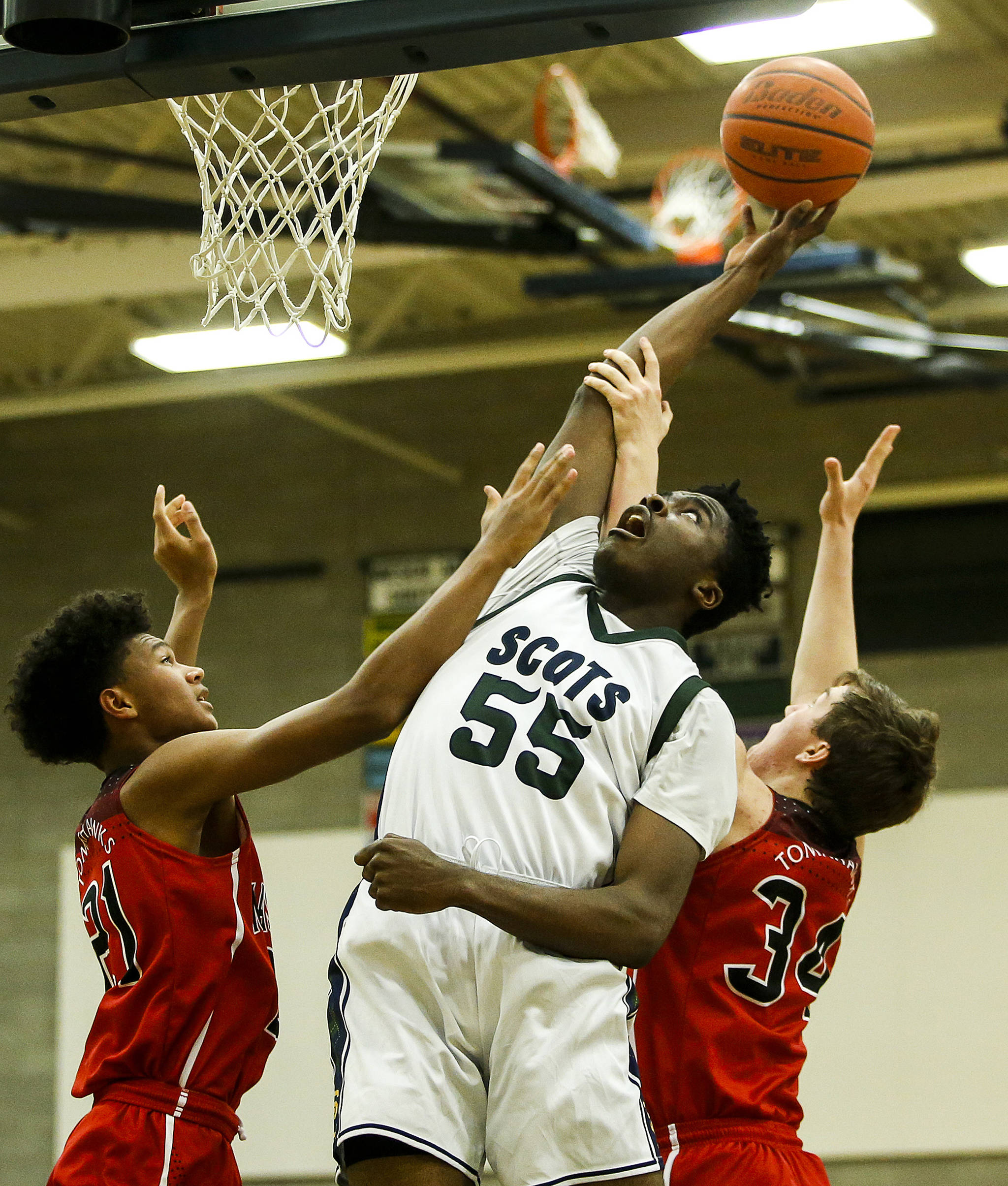 Shorecrest’s Philip Pepple (center) tips a shot back towards the hoop above Marysville Pilchuck’s RaeQuan Battle (left) and Corbin Sims (right) during a game on Jan. 9, 2018, at Shorecrest High School in Shoreline. (Ian Terry / The Herald)