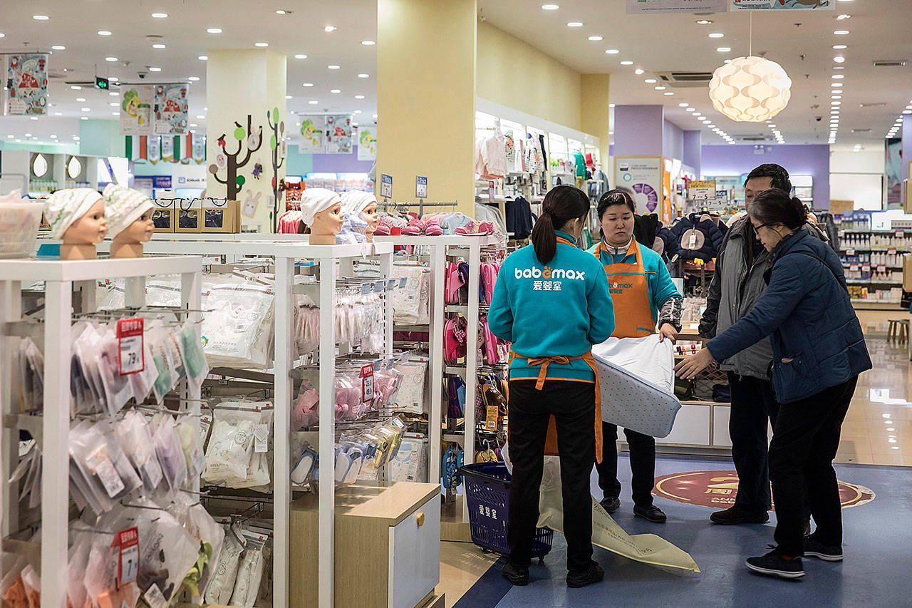 Employees show a mattress to customers at a Babemax store in Shanghai, China, on Dec. 22. (Bloomberg/Qilai Shen)