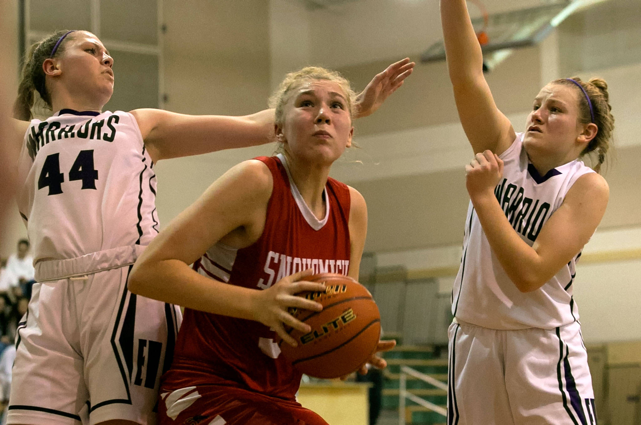 Snohomish’s Kyra Beckman (center) gathers for a shot attempt with Edmonds-Woodway’s Adrienne Poling (left) and AJ Martineau defending during a game Jan. 12, 2018, at Edmonds-Woodway High School. The Panthers won 66-64. (Kevin Clark / The Herald)