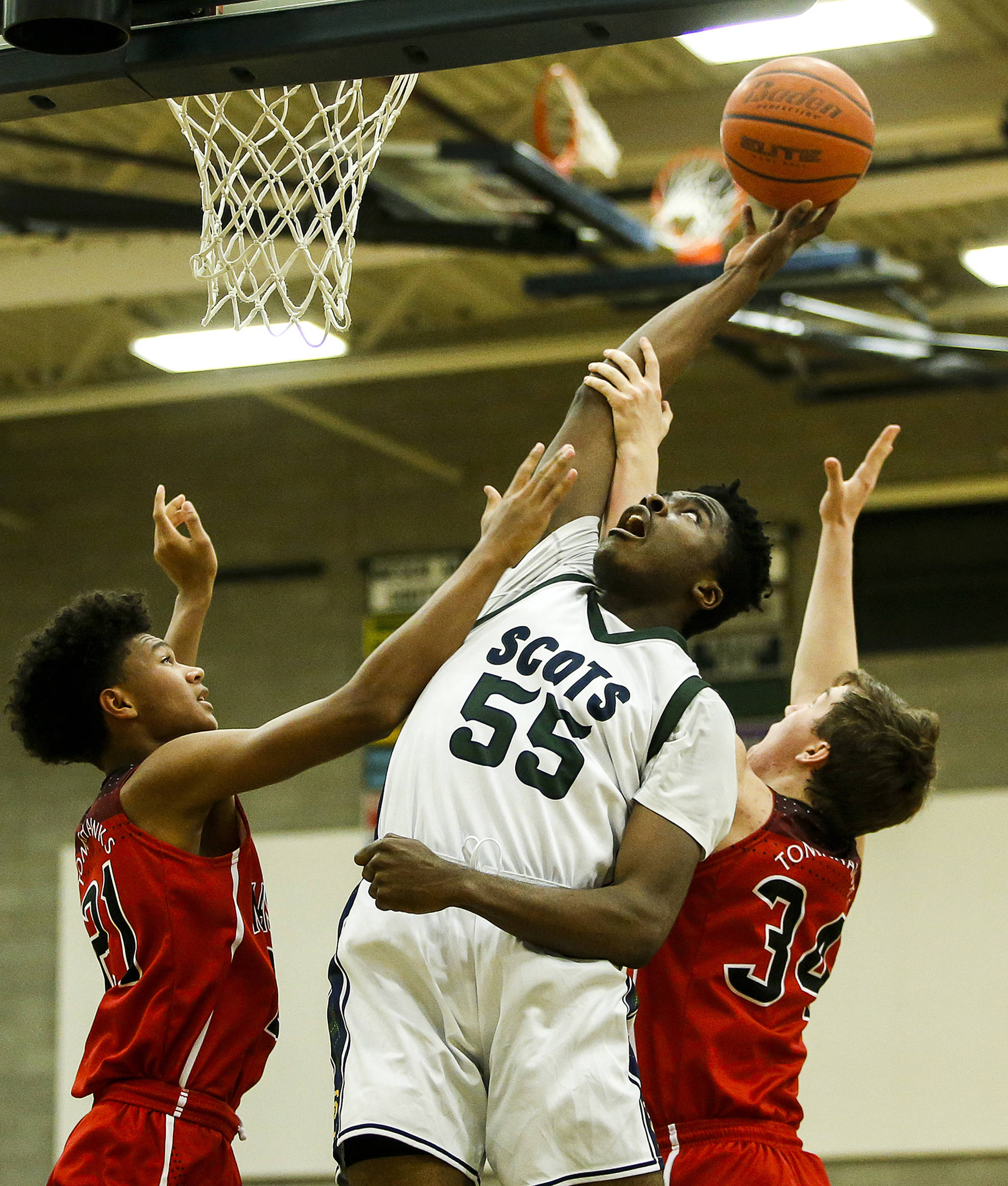 Shorecrest’s Philip Pepple (center) tips a shot back toward the hoop above Marysville Pilchuck’s Raequan Battle (left) and Corbin Sims (right) during a game at Shorecrest High School in Shoreline on Jan. 9. (Ian Terry / The Herald)