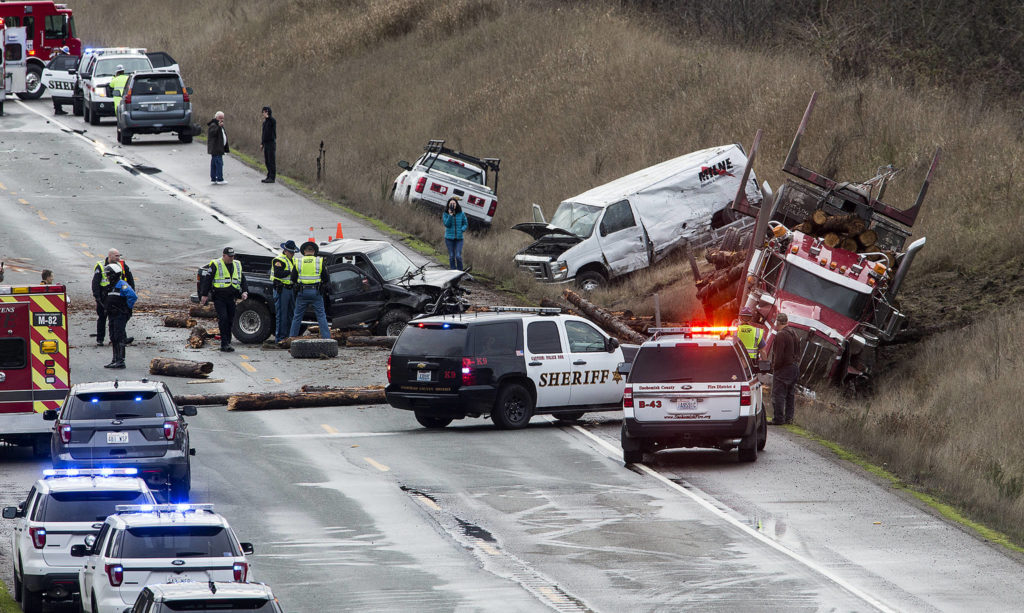 Law enforcement officers examine the area of a six-vehicle pileup on U.S. 2 that caused serious injuries and shut down the road in both directions on Jan. 8 in Snohomish. (Andy Bronson / The Herald)
