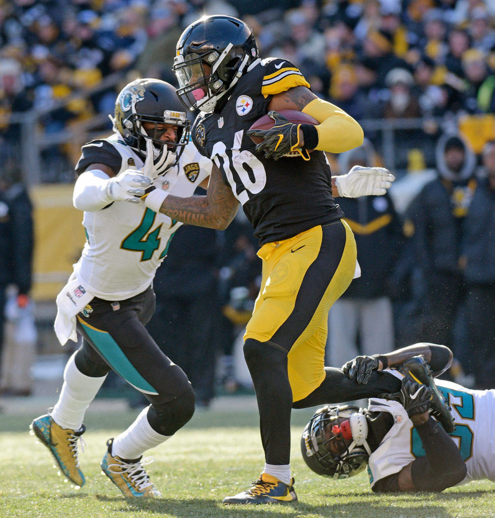 Pittsburgh Steelers running back Le’Veon Bell (26) is tackled by Jacksonville Jaguars free safety Tashaun Gipson, lower right, and strong safety Barry Church, left, during the first half of an NFL divisional football AFC playoff game in Pittsburgh, Sunday, Jan. 14, 2018. (AP Photo/Don Wright)
