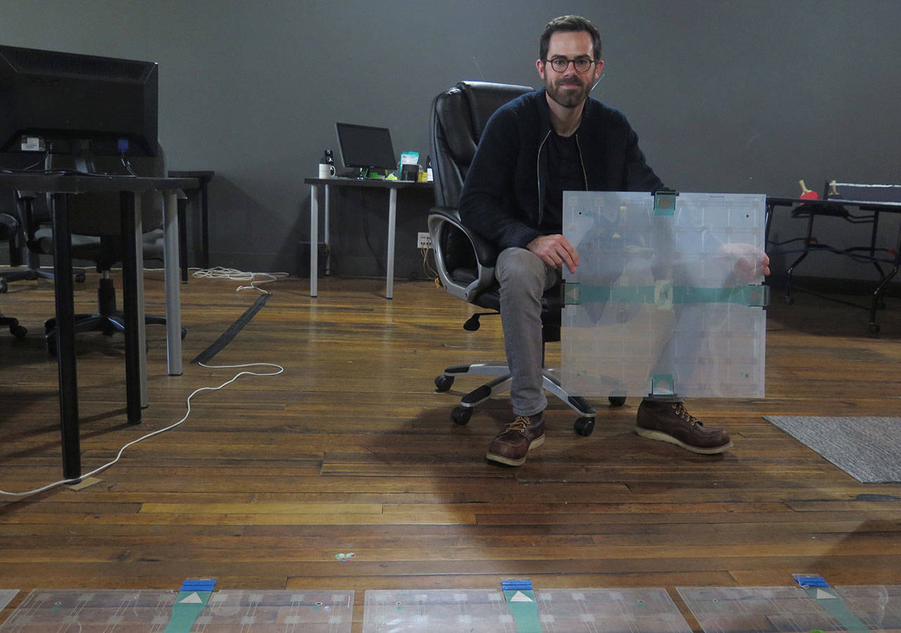In this photo taken Dec. 5, 2017, Scanalytics co-founder and CEO Joe Scanlin holds a smart floor sensor his company creates that track people’s movements in Milwaukee. The sensors are among the tools retailers are using to gain insights on consumer habits. (AP Photo/Ivan Moreno)