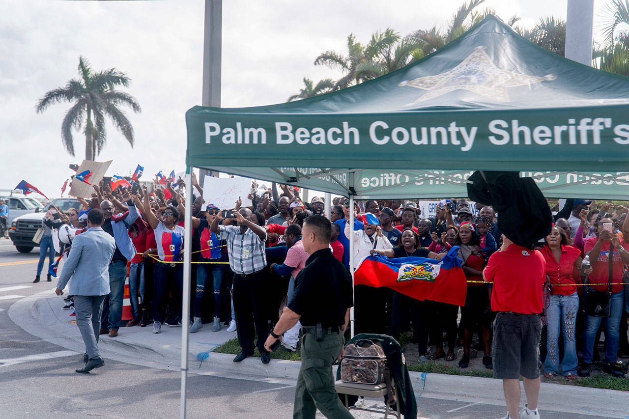Anti-Trump protesters line the sidewalks as President Donald Trump’s motorcade returns to Mar-a-Lago in West Palm Beach, Fla., Monday, Jan. 15, 2018, after Trump played golf at Trump International Golf Club. (AP Photo/Andrew Harnik)