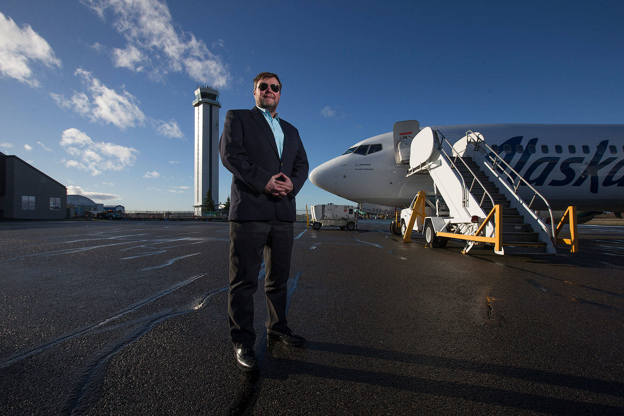 John Kirby, Alaska’s vice president of capacity planning, stands in front of a 737-800 and the Paine Field Tower on Tuesday in Everett. Eight new routes will be operating from Paine Field to five California locales and three others. (Andy Bronson / The Herald)