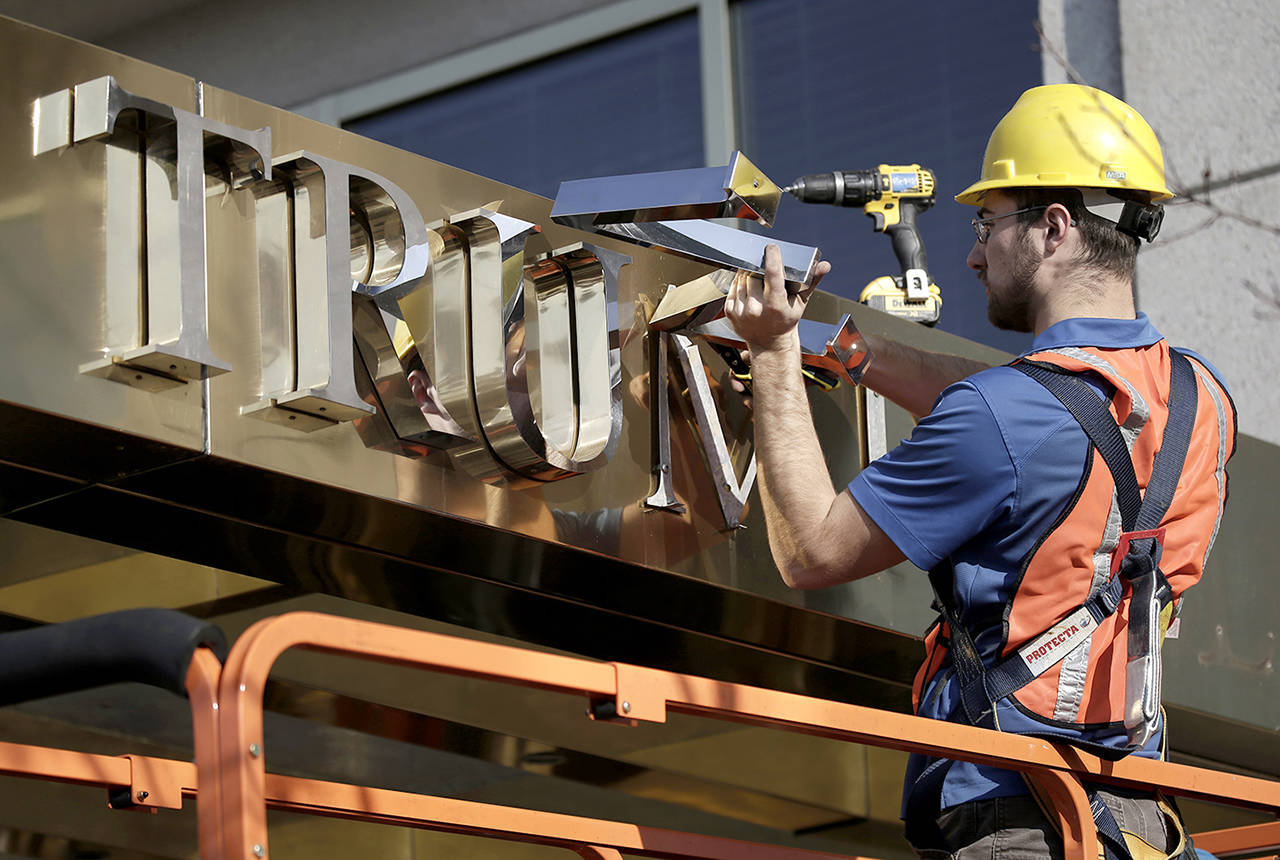 A worker removes the words “Trump Place” from a residential building Nov. 16, 2016, in New York. (Peter Foley / Bloomberg file)