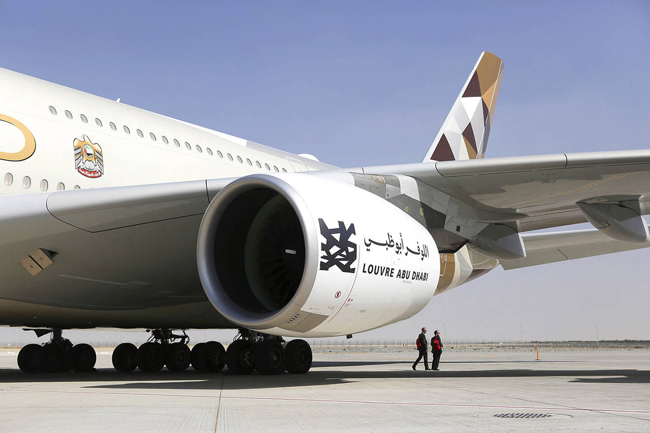 Attendees pass an Airbus A380 passenger aircraft, operated by Etihad Airways, on the tarmac during the 15th Dubai Air Show at Dubai World Central in Dubai, United Arab Emirates, on Nov. 13, 2017. (Natalie Naccache/Bloomberg)