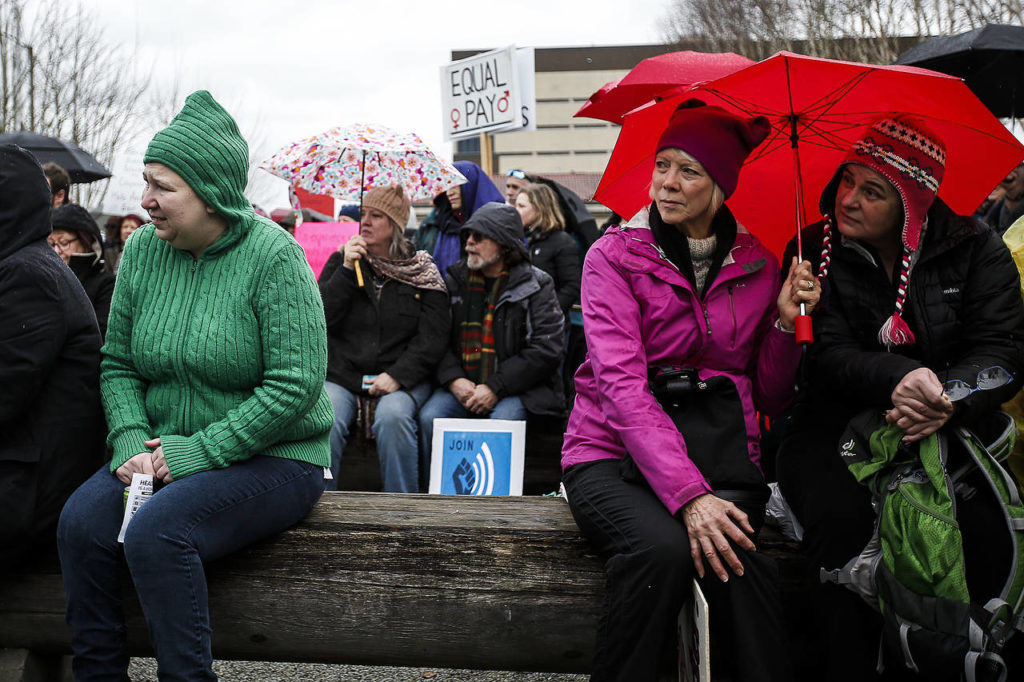 At the Snohomish County courthouse in Everett, people gather to listen to speakers during a rally to protest the 1-year anniversary of the inauguration of President Donald Trump on Saturday. (Ian Terry / The Herald)

