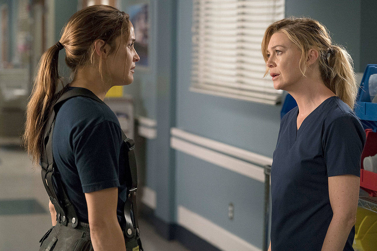 This image released by ABC shows Jaina Lee Ortiz, left, and Ellen Pompeo in a scene from a yet untitled spinoff episode of “Grey’s Anatomy.” The new series, debuting with a two-hour episode on March 22, will follow a group of Seattle firefighters. (ABC/Mitch Haaseth via AP)