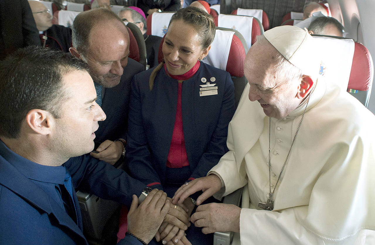 Pope Francis marries flight attendants Carlos Ciuffardi (left) and Paola Podest (center) during a flight from Santiago, Chile, to Iquique, Chile, on Thursday. (L’Osservatore Romano Vatican Media/Pool Photo via AP)