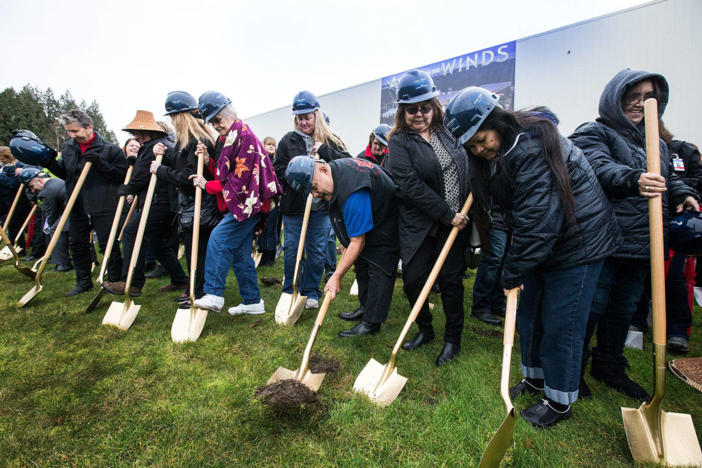 David Allen (center) flips up a mound of dirt as Stillaguamish tribal members and guests shovel holes during a groundbreaking ceremony for a more than $60 million expansion at the Angel of the Winds Casino Resort on Tuesday in Arlington. (Andy Bronson / The Herald)
