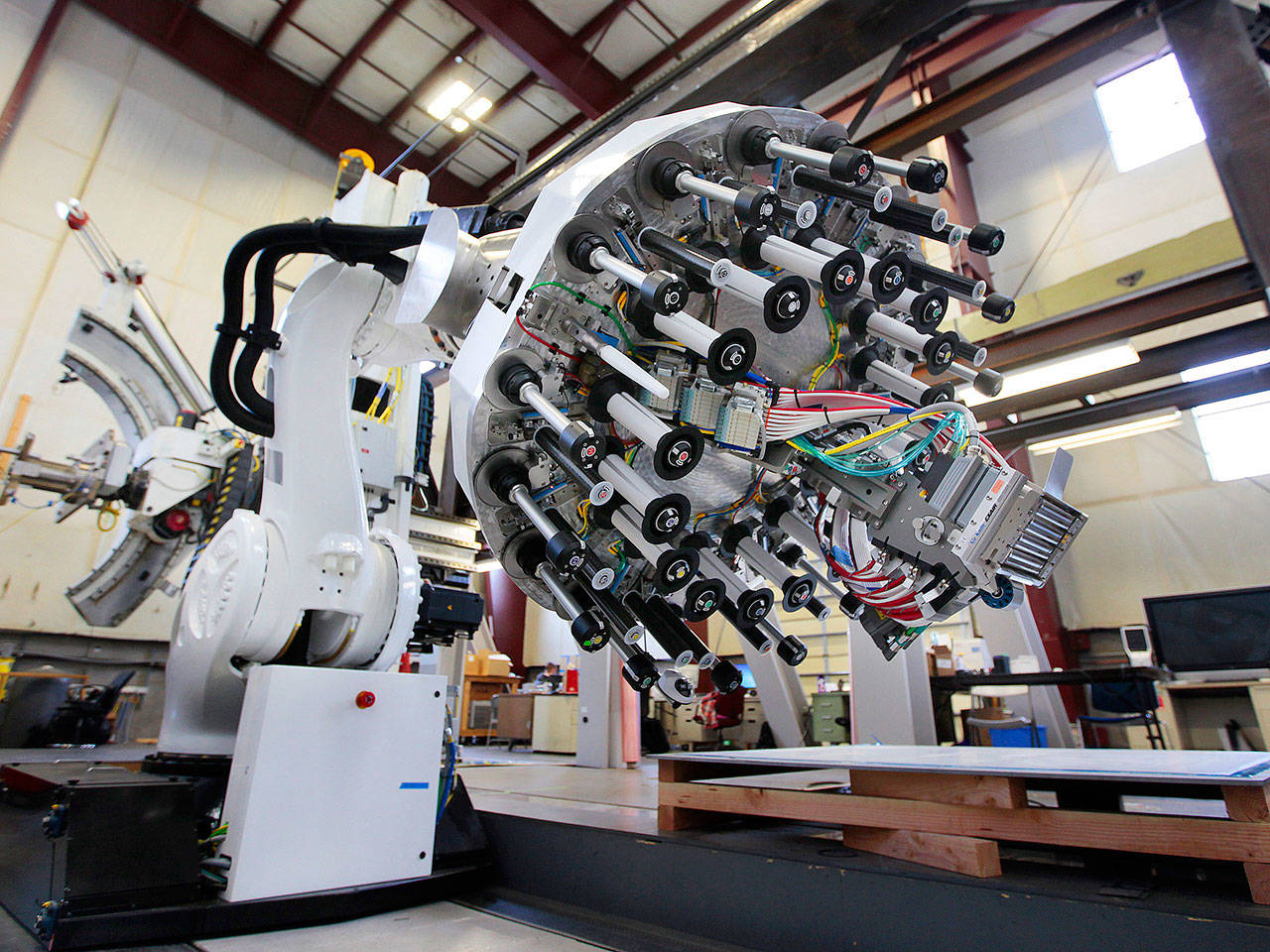 An automated fiber placement robot that Electroimpact uses for tests is seen inside one of the company’s buildings near Paine Field in 2014. The company is laying off 66 employees, about 9 percent of its workforce. (Mark Mulligan / The Herald)