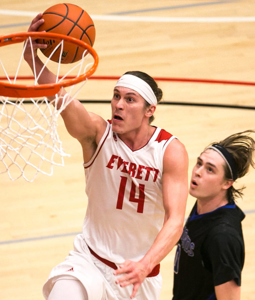 Everett Community College’s Conner Moffatt (14) drives for a layup with Edmonds Community College’s Jake Higgins trailing during a game Jan. 20, 2018, at the Walt Price Student Fitness Center in Everett. The Trojans won 117-100. (Kevin Clark / The Herald)
