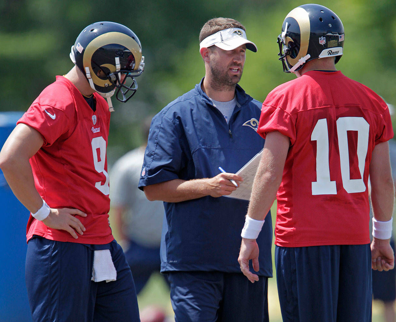 Former Rams offensive coordinator Brian Schottenheimer (center) talks with quarterbacks Kellen Clemens (10) and Austin Davis (9) during practice on June 14, 2012 in St. Louis. (AP Photo/Tom Gannam)