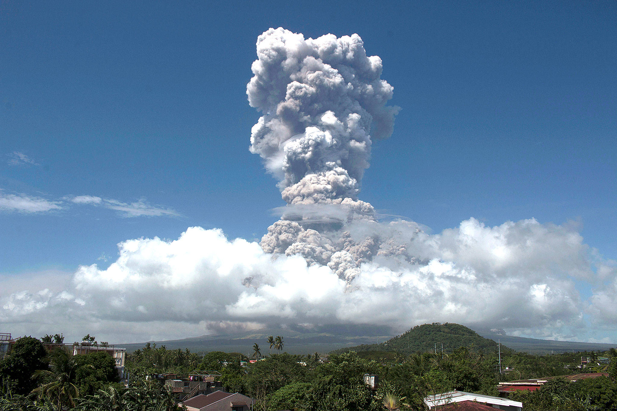 A huge column of ash shoots up to the sky during the eruption of the volcano Mayon on Monday, as seen from Legazpi city, Albay province, around 340 kilometers (200 miles) southeast of Manila, Philippines. (AP Photo/Earl Recamunda)