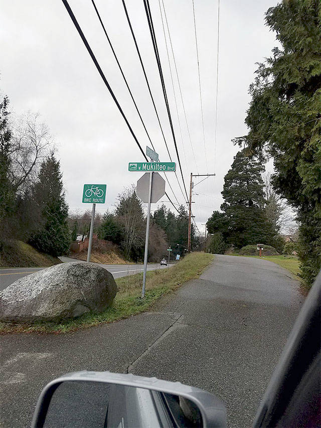 For a short time in January, main thoroughfare Mukilteo Boulevard and little side street Baker Drive swapped places. City crews have since twisted the new street signs back into place. Resident Chuck Newcombe was just glad the giant boulder didn’t budge, since it makes a handy marker for giving visitors directions. (Contributed photo)