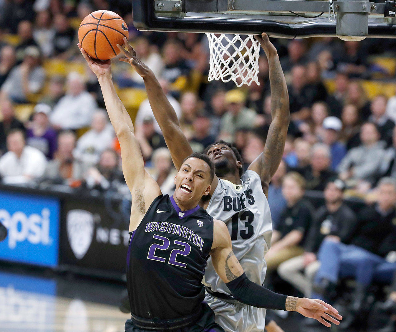 Washington’s Dominic Green (front) is fouled at the rim by Colorado’s Namon Wright during the first half of the Huskies’ 72-62 win against the Buffaloes on Saturday in Boulder, Colo. (AP Photo/David Zalubowski)