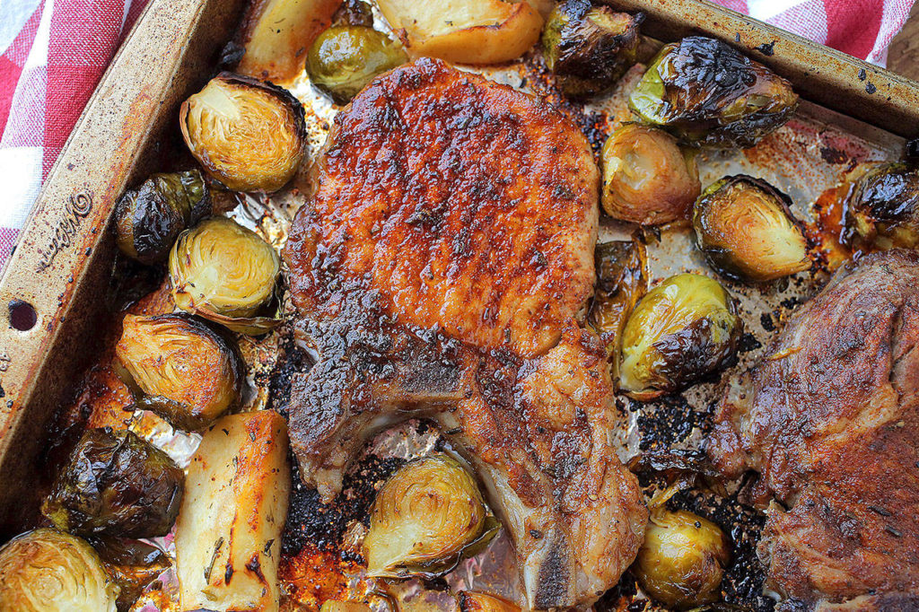 A pan of pork chops with roasted apples and Brussels sprouts is a one-sheet meal with a nice balance of sweet and bitter. (Cristina M. Fletes/St. Louis Post-Dispatch)
