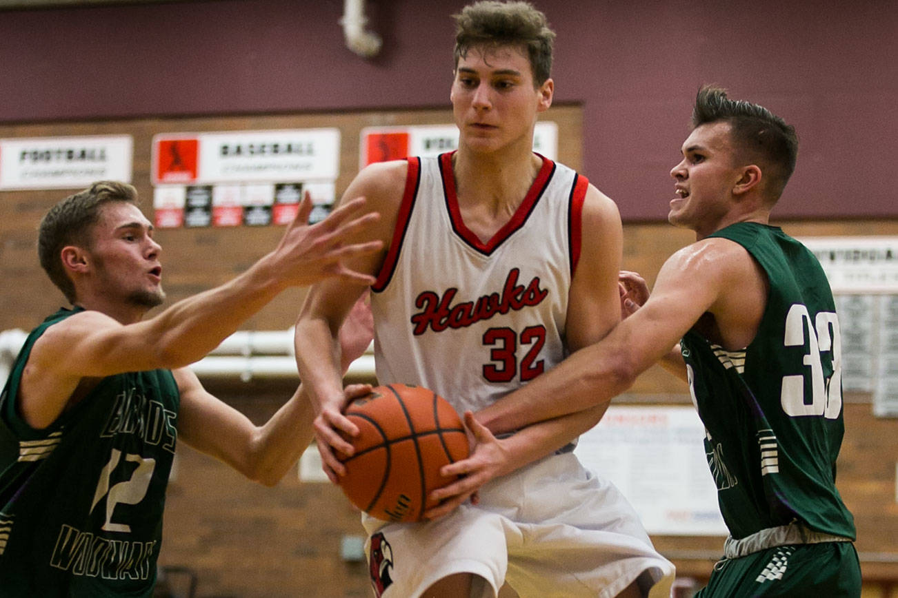 Mountlake Terrance’s Brendan Hayes gathers rebound with Edmonds-Wooway’s Noah Becker (left) and Kameron Eck Tuesday night at Mountlake Terrace High School on January 23, 2018. (Kevin Clark / The Daily Herald)