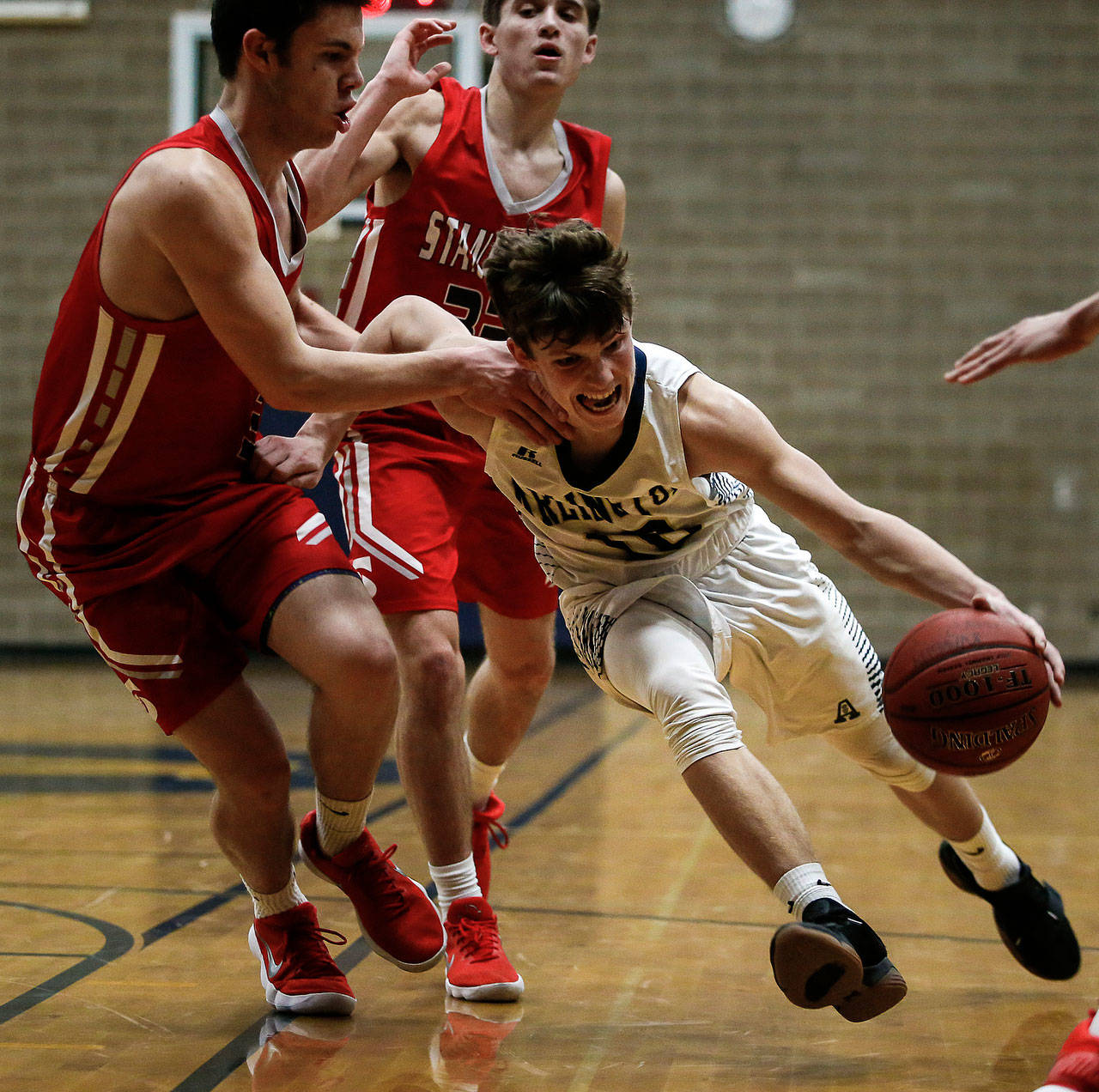 Ian Terry / The Herald                                Arlington’s Anthony Whitis (right) drives to the basket during Friday’s game at Arlington High School.