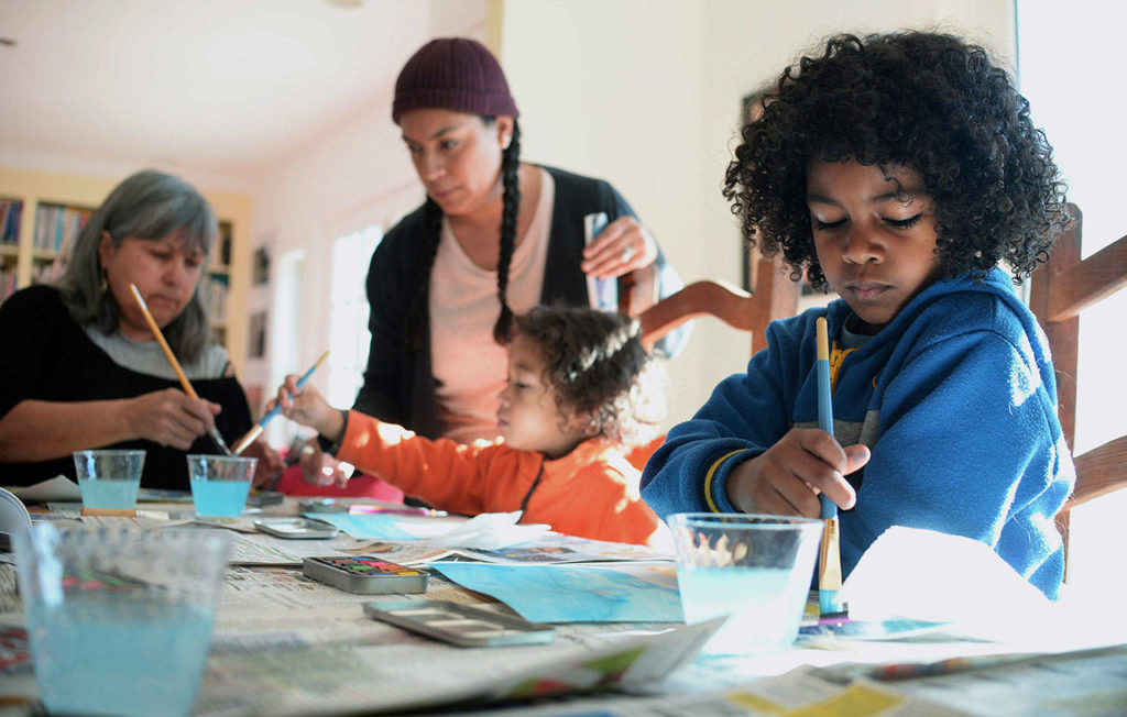 Judah James, right, paints during a home school art class with his grandmother, artist Maybeth Morales, left, mother, Chemay Morales-James, standing, and younger brother Keanu in Watertown, Conn., on Jan. 26, 2018. Reports that 13 malnourished siblings allegedly held captive by their parents were home-schooled has others who educate their children at home bracing for calls for more oversight of the practice, a reaction they say would unfairly punish families. (AP Photo/Jessica Hill) 
