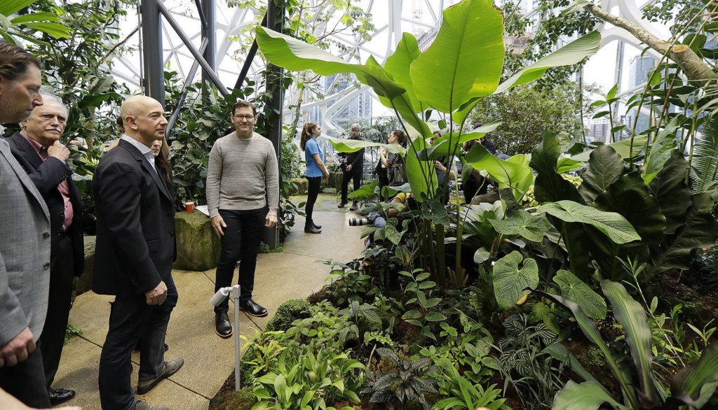 Jeff Bezos, third from left, the CEO and founder of Amazon.com, takes a walking tour of the Amazon Spheres, three plant-filed geodesic domes that serve as a work- and gathering place for Amazon employees, following a grand opening ceremony, Monday in Seattle. (AP Photo/Ted S. Warren)
