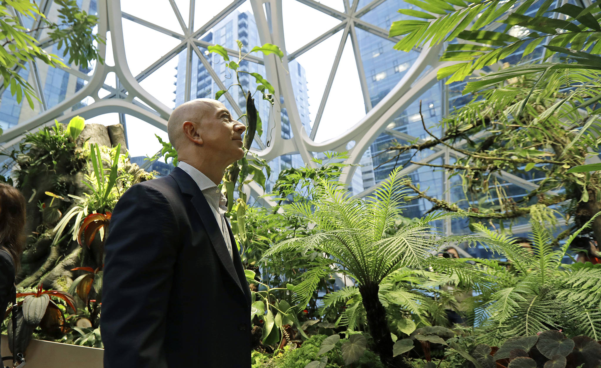 Jeff Bezos, the CEO and founder of Amazon.com, takes a walking tour of the Amazon Spheres, three plant-filed geodesic domes that serve as a work- and gathering place for Amazon employees, following a grand opening ceremony, Monday in Seattle. (AP Photo/Ted S. Warren)