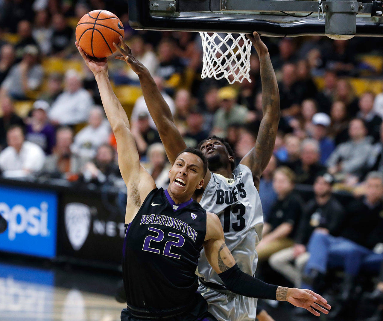 Washington’s Dominic Green is fouled by Colorado’s Namon Wright during the first half of a Jan. 20 game. (AP Photo/David Zalubowski)