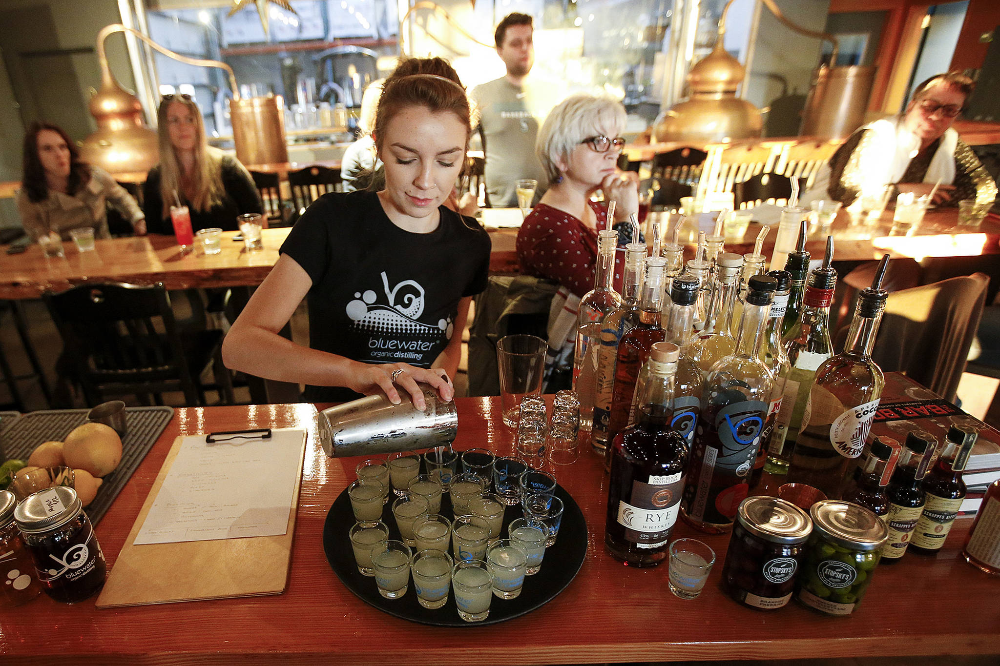 Cocktail samples are served up during a Cocktail Tuesday class at Bluewater Distilling in Everett. The classes are offered once a month to teach people tricks of the trade to take home. Below, Bluewater Distilling owner, John Lundin, gives a lesson on tools used for making cocktails. (Ian Terry / The Herald)