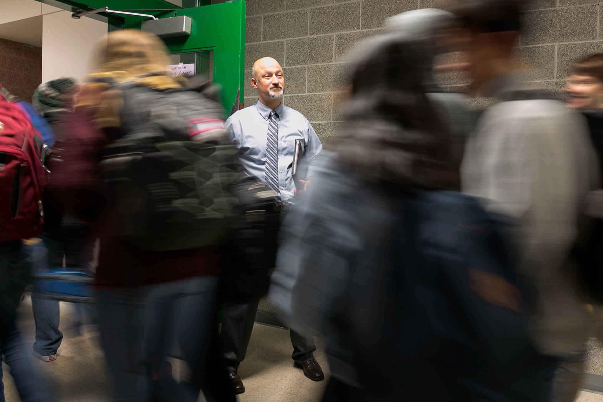 Principal Dave Peters holds the door for students exiting first lunch Monday morning at Henry M. Jackson High School in Mill Creek on Jan. 22. (Kevin Clark / The Daily Herald)