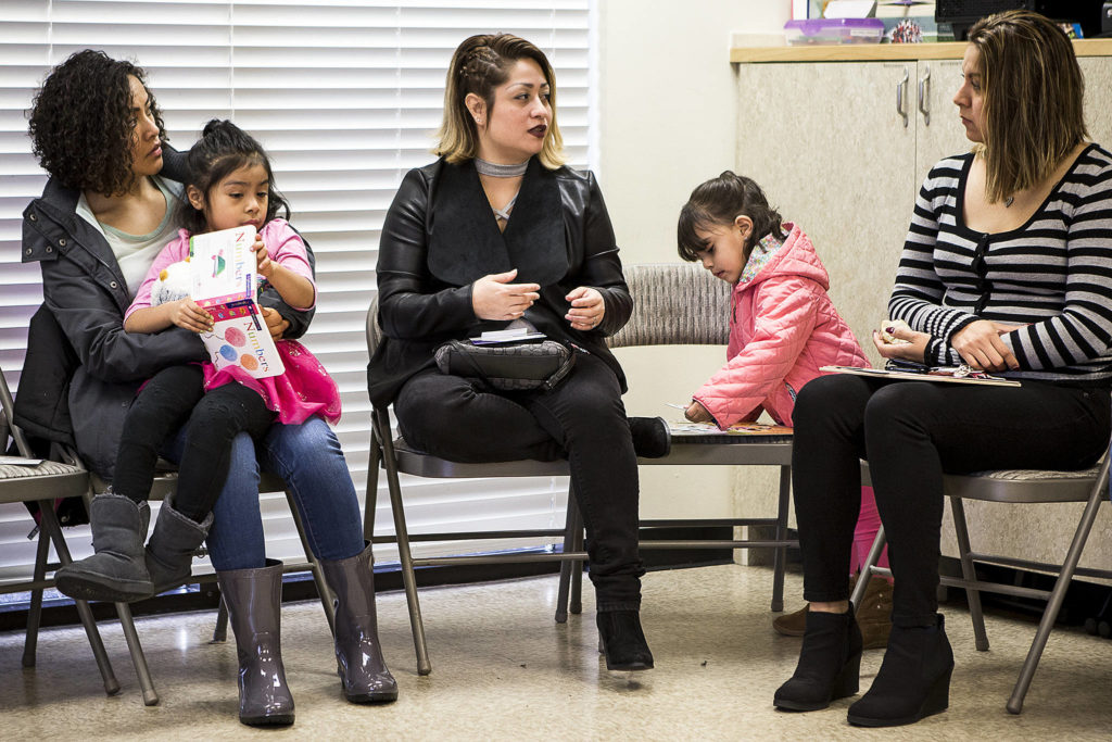 Ruth Bermudez (center) talks with members of a weekly coffee hour at Hand In Hand, a nonprofit on E. Casino Road in Everett, on Jan. 12. (Ian Terry / The Herald)
