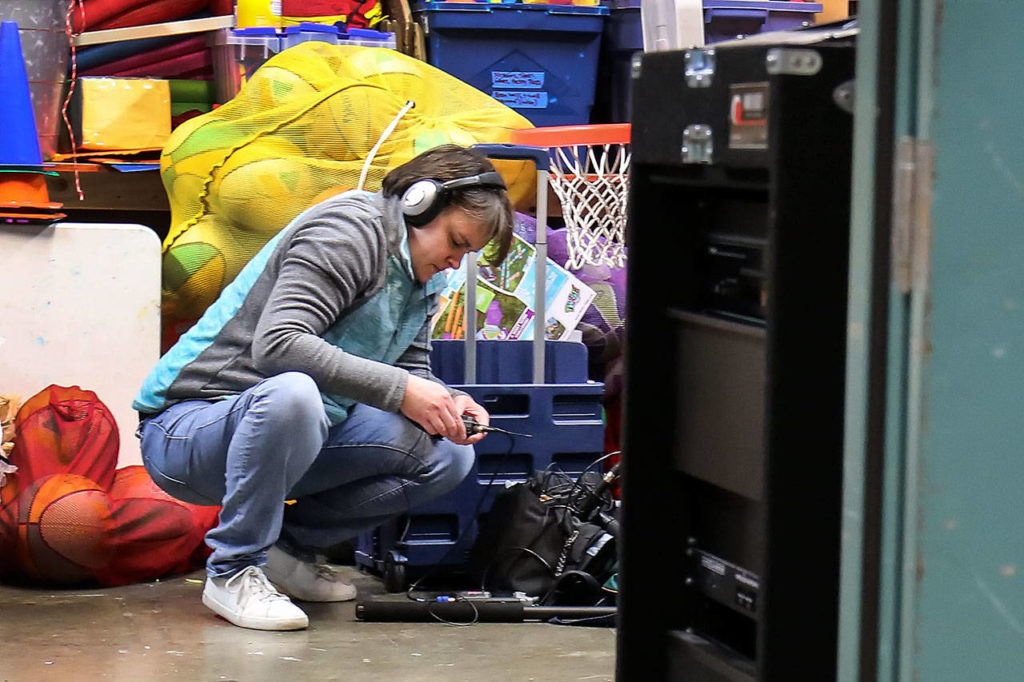 Kelly Hills check her sound gear before the performance. (Kevin Clark / The Daily Herald)
