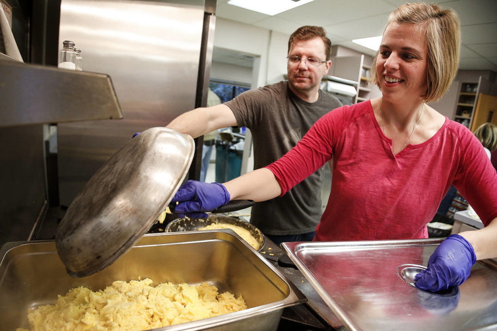 Volunteers Travis and Kelly Silvers, of Lynnwood, make scrambled eggs at the Neighbors in Need breakfast at Trinity Lutheran in Lynnwood on Jan. 27. (Ian Terry / The Herald)
