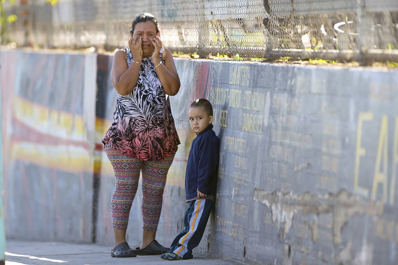 Elizabeth Acevedo and her son Andres, 3, wait for news of her son Jose, an eighth-grader at Belmont High School in Los Angeles, on Thursday after a shooting at Salvador B. Castro Middle School. (Damian Dovarganes)