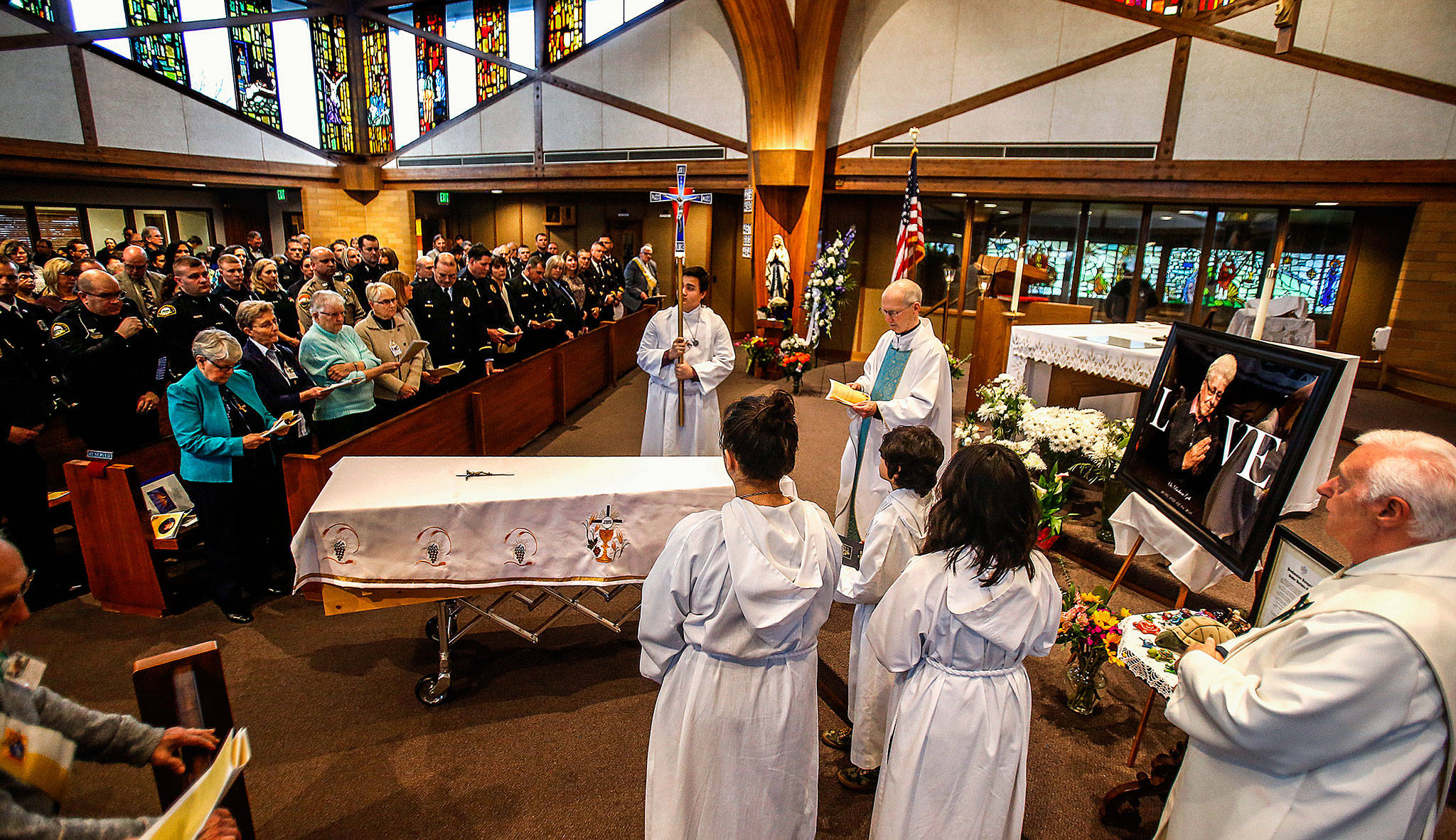 At a funeral Mass for Sister Barbara Geib at St. Mary of the Valley Catholic Church in Monroe Thursday, the Rev. Phillip Bloom officiates as police, firefighters, nuns from Geib’s religious order and others listen and take part. Geib, a parish sister at the church, was Monroe’s first police chaplain. (Dan Bates / The Herald)