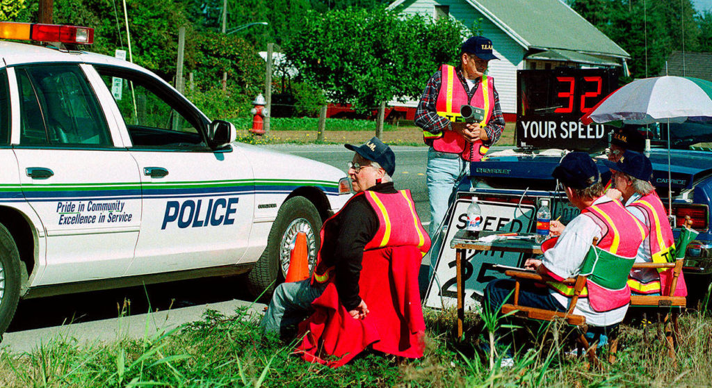 Sister Barbara Geib (seated, left) joined other members of a Traffic Education and Monitoring (TEAM) group keeping watch on Main Street in Monroe in 1998 as an officer stops by. Geib, a longtime chaplain with Monroe police and fire departments and a parish sister at St. Mary of the Valley Catholic Church, died Feb. 4 at age 85. (Herald file / Justin Best)
