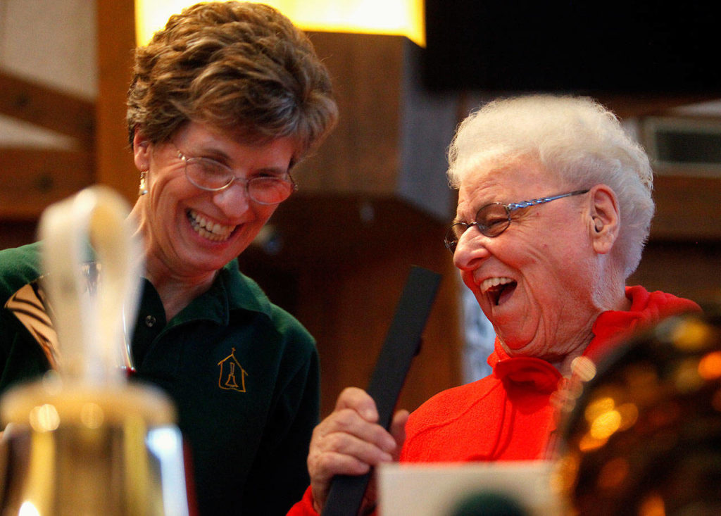 On May 30, 2012, Sister Barbara Geib (right) laughs with a member of the Angelus Handbell Choir at St. Mary of the Valley Catholic Church in Monroe. Geib, a longtime police chaplain and parish sister at the church died Feb. 4. (Annie Mulligan / For The Herald)
