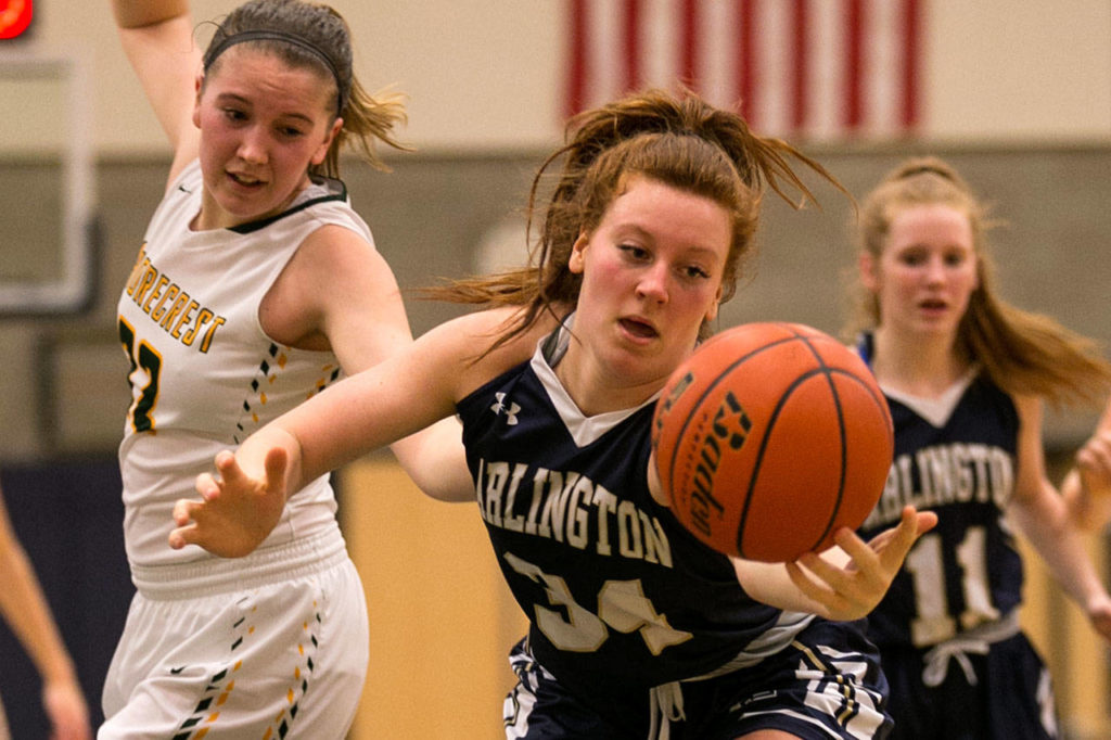 Arlington’s Kelsey Mellick reaches for a loose ball Fridayt at Shorecrest High School. (Kevin Clark / The Daily Herald)
