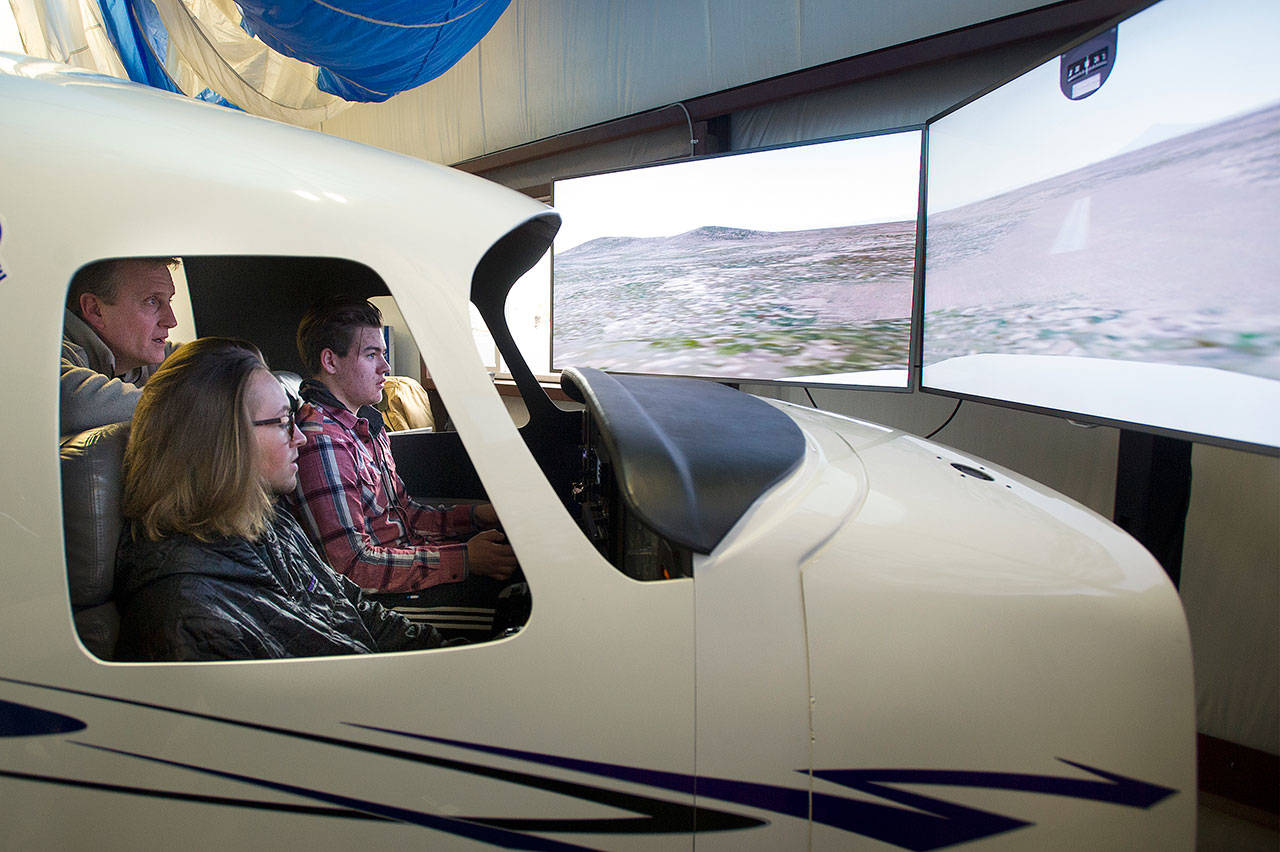 Certified flight instructor Walt Lasecki helps talk Aaron Johnson, above, and Luke Perie through a landing in the flight simulator at Outlaw Aviation in Sisters, Oregon, on Jan. 24. (Ryan Brennecke / The Bulletin)