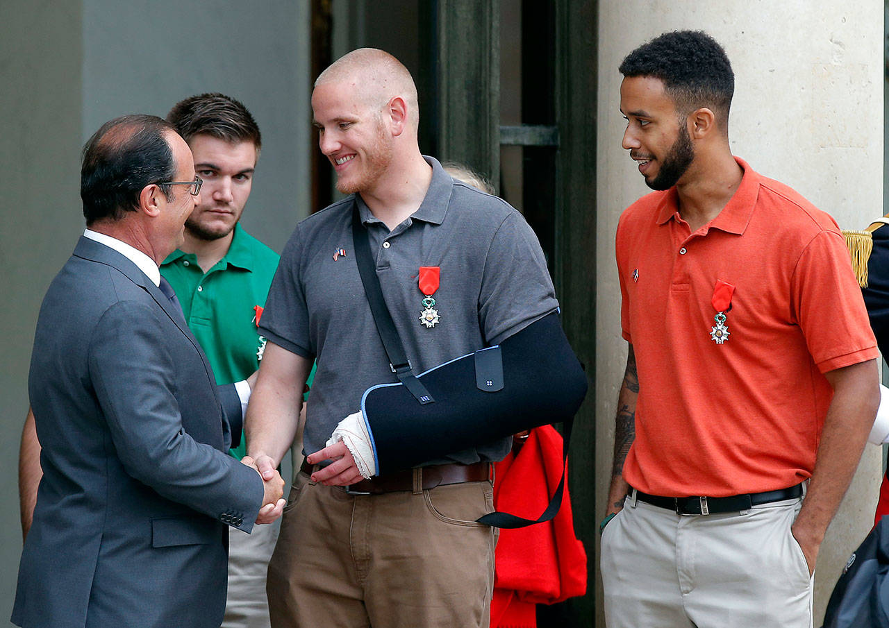French President Francois Hollande bids farewell to U.S. Airman Spencer Stone as U.S. National Guardsman Alek Skarlatos, of Roseburg, Oregon (second from left), and Anthony Sadler, a senior at Sacramento State University in California, look on on Aug. 24, 2015, after Hollande awarded them with the French Legion of Honor at the Elysee Palace in Paris. (Michel Euler / Associated Press file)