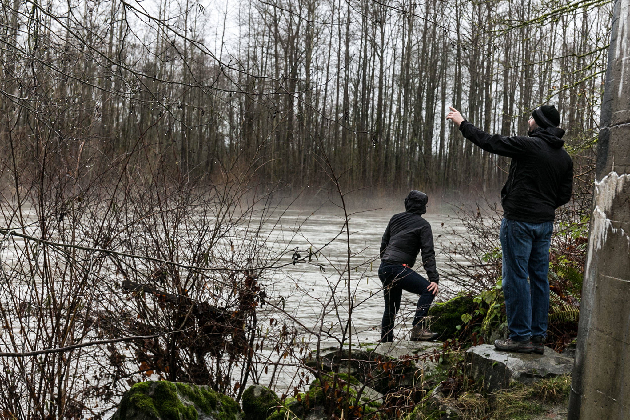 Kirsten Lee (left) and Dustin Lee take in the rising waters of the Stillaguamish River on Sunday afternoon at Haller Park in Arlington. (Kevin Clark / The Daily Herald)