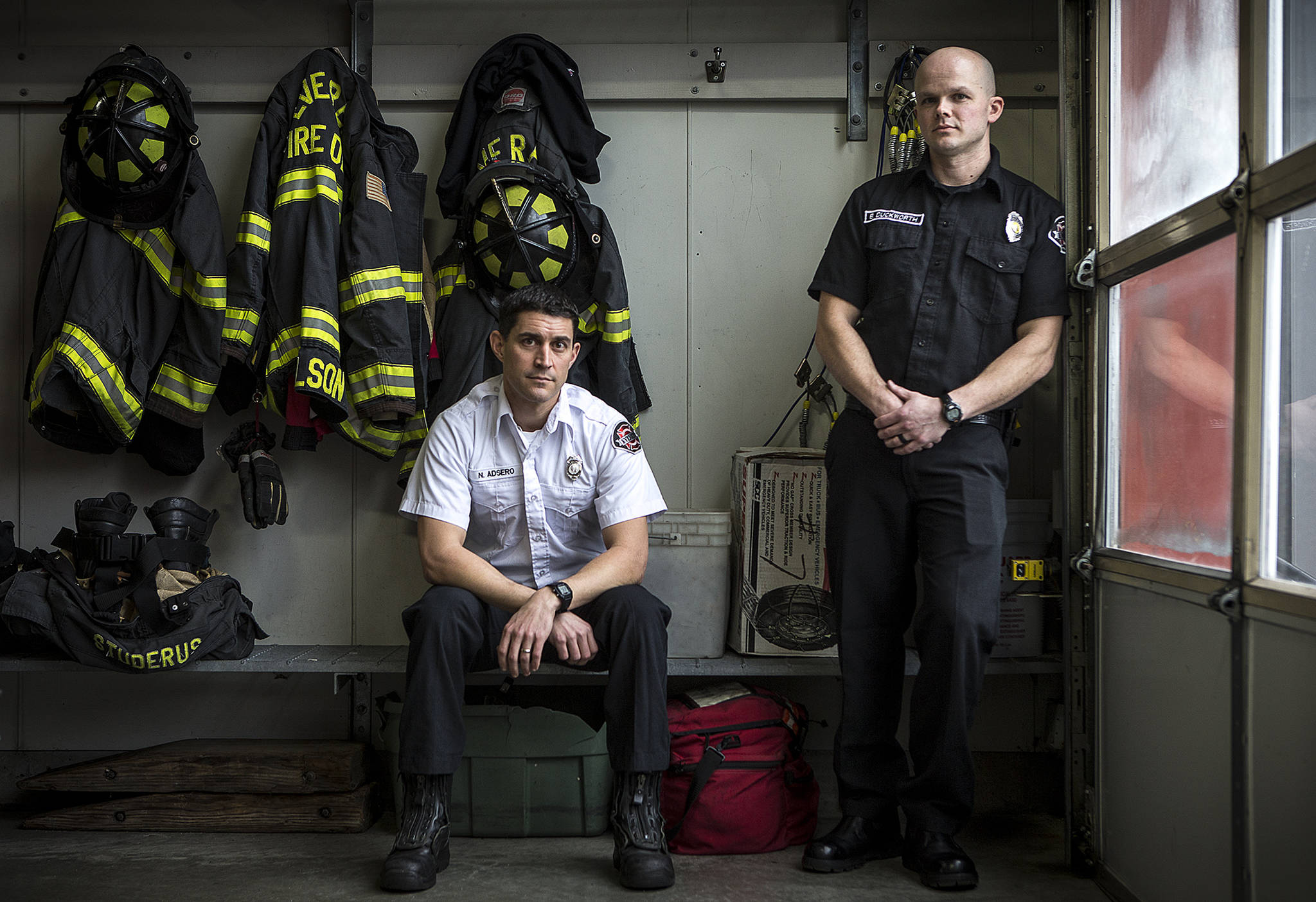 Capt. Nick Adsero (left) and firefighter Brent Duckworth braved thick black smoke and flames to save trapped 3-year-old twin sisters Chloe and Emma Orick at a Jan. 29 fire at Olin Fields Apartments in Everett. (Ian Terry / The Herald)