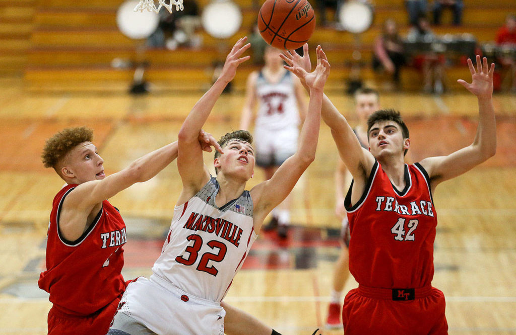Mountlake Terrace’s Max Hull (right) tips the ball away from Marysville Pilchuck’s Aaron Kalab (32) on Monday in Marysville. Hull and the Hawks beat Kalab and the Tomahawks 63-52. (Andy Bronson / The Herald)
