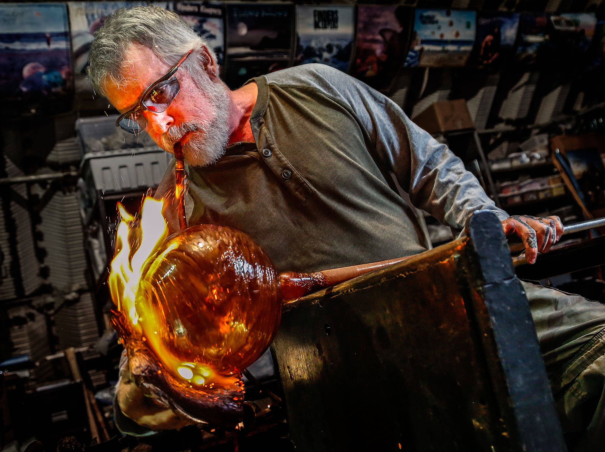 Mark Ellinger works to create unique texture and color on a glass float. He and his son made hundreds of floats for this year’s Great Northwest Glass Quest. (Dan Bates / The Herald)