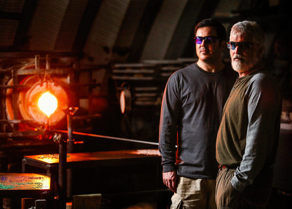Mark Ellinger and his son, Marcus have been busy making the glass floats for the Great Northwest Glass Quest, which runs through Feb. 25. (Dan Bates / The Herald)
